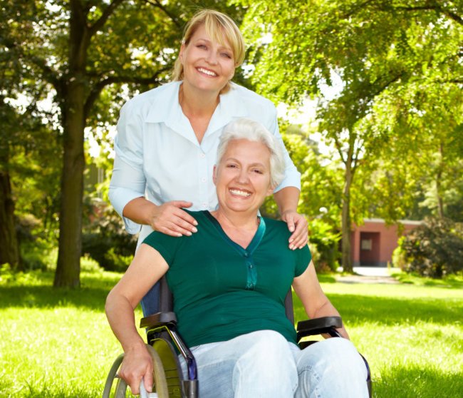 Senior woman in wheelchair with nurse