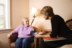 nurse checks an elderly woman blood pressure